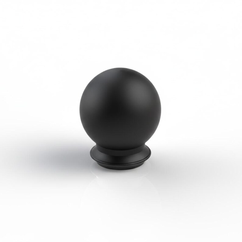 May include: A black, spherical finial with a matte finish. The finial sits on a decorative base with a rounded profile. The object is set against a white background, highlighting its shape and colour.