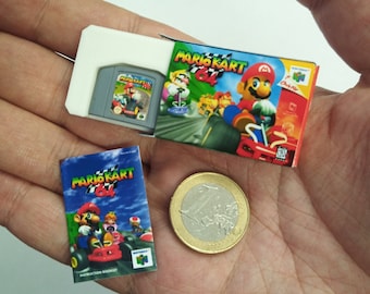 May include: A miniature Nintendo 64 game cartridge and box for Mario Kart 64, along with the instruction booklet and a Euro coin for scale.
