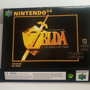 Peut inclure: Une boîte de jeu Nintendo 64 noire avec un logo or et blanc pour The Legend of Zelda: Ocarina of Time. La boîte est étiquetée "Version PAL" et "PAL-Versie".