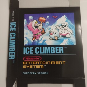 Könnte beinhalten: Eine schwarze Nintendo Entertainment System-Spielkassette mit weißem Rand. Die Schachtel zeigt eine bunte Illustration von zwei Charakteren aus dem Spiel Ice Climber. Der Text auf der Schachtel lautet "Ice Climber" und "Nintendo Entertainment System".