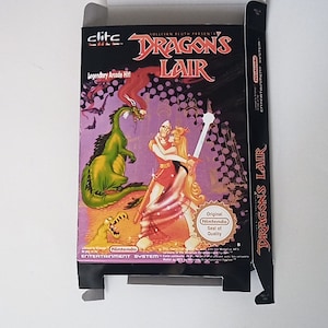May include: A black and red Nintendo Entertainment System game box for Dragon's Lair. The box features a green dragon and a knight with a sword fighting a woman in a red dress. The box has the text "Dragon's Lair" in large white letters and "Legendary Arcade Hill" in smaller white letters.