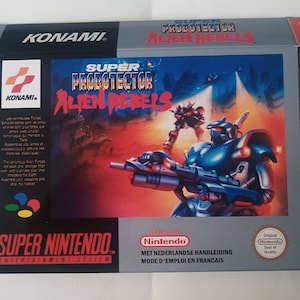 Peut inclure: Une boîte de jeu Super Nintendo Entertainment System pour Super Probotector: Alien Rebels. La boîte est argentée avec une image rouge, orange et noire d'un robot tenant un fusil. Le texte "Super Probotector: Alien Rebels" est imprimé en blanc sur fond noir.