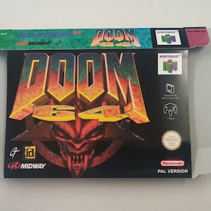 May include: A black Nintendo 64 game cartridge case with a red, yellow, and green DOOM 64 logo. The case has a black and red demon face with sharp teeth. The text "PAL VERSION" is printed on the bottom right corner of the case.