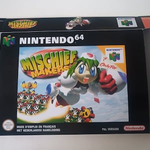 Może przedstawiać: Otwarta skrzynka z grą Nintendo 64 dla "Mischief Makers". Czarne pudełko z kolorową grafiką postaci z zielonymi włosami i białym strojem. Tytuł gry jest żółty, a logo Nintendo jest widoczne.