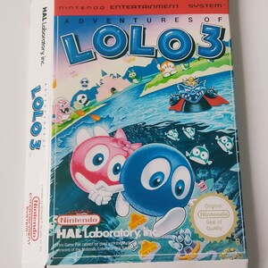 May include: An open Nintendo Entertainment System game box for "Adventures of Lolo 3." The box art shows cartoon characters in a blue and green underwater scene. The game title and "Nintendo" are visible. The box is in good condition.