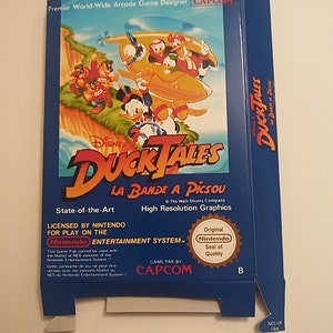 Könnte beinhalten: Eine blaue Nintendo-Spielkassettenbox für DuckTales: La Bande a Picsou. Die Box zeigt eine farbenfrohe Illustration der Figuren aus dem Disney-Cartoon, darunter Dagobert Duck, Tick, Trick und Track. Die Box enthält auch den Text "State-of-the-Art", "Licensed by Nintendo for play on the Nintendo Entertainment System", "Game Pak by Capcom", und "Original Nintendo Seal of Quality".