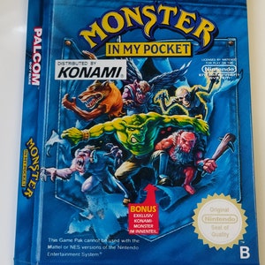 Può includere: Una scatola blu di Nintendo Game Pak per Monster in My Pocket, un videogioco distribuito da Konami. La scatola presenta un'illustrazione colorata di mostri e il testo "Bonus Exclusiv Konami-Monster Im Innenteil".
