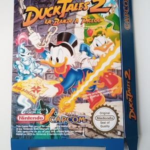 Op de afbeelding: Een blauwe en witte Nintendo-spelcartridge doos voor DuckTales 2: De Jacht op de Gouden Eend. De doos heeft een cartoon afbeelding van Dagobert Duck, Kwik, Kwek en Kwak. De tekst op de doos luidt "DuckTales 2: La Bande a Picsou" en "Game Pak by Capcom".