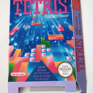 Pode incluir: Uma caixa de cartucho de jogo Nintendo azul e rosa para Tetris. A caixa apresenta uma ilustração colorida de blocos que caem e o texto "The relentless building block video puzzle. Le casse-tête vidéo qui casse vraiment la tête. Tetris".