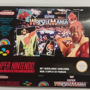 Peut inclure: Une boîte de jeu Super Nintendo Entertainment System pour WWF Super Wrestlemania. La boîte présente un fond noir avec une image colorée de lutteurs sur le ring. Le texte "WWF Super Wrestlemania" est imprimé en blanc sur fond rouge.