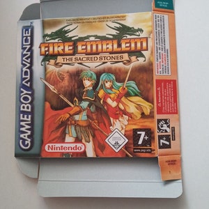 Könnte beinhalten: Geöffnete Game Boy Advance Spielbox für "Fire Emblem: The Sacred Stones". Die Box zeigt zwei Charaktere mit Waffen. Das Nintendo-Logo und der Spieletitel sind zu sehen.