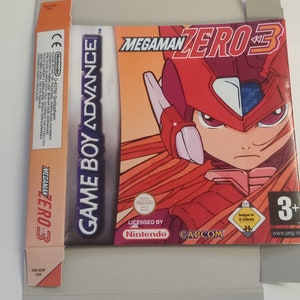 May include: A red and white Game Boy Advance game cartridge case with the title "Mega Man Zero 3" and a picture of the character Mega Man Zero. The case is licensed by Nintendo and published by Capcom.