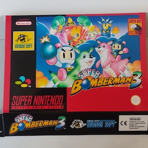 Puede incluir: Una caja de juego de Super Nintendo roja, blanca y azul para Super Bomberman 3. La caja presenta una imagen de dibujos animados del personaje de Bomberman y otros personajes del juego. La caja está en buen estado y tiene algunos rasguños menores.