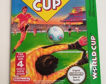 Może przedstawiać: Zielone, żółte i białe pudełko gry Nintendo World Cup z obrazkiem piłkarza kopiącego piłkę i bramkarza nurkującego, aby ją zablokować. Pudełko zawiera napis "Gra dla czterech graczy" i "Oryginalna Pieczęć Jakości Nintendo".