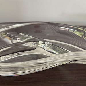 Könnte beinhalten: Klarer Servierteller aus Glas mit einem einzigartigen, fließenden Design. Der Teller ist in drei Abschnitte unterteilt und weist geätzte Blattmuster auf. Die geschwungene Form und das transparente Material schaffen eine elegante Ästhetik.