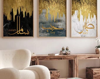 May include: Three framed canvas prints with gold leaf accents and Arabic calligraphy. The prints feature the words "salam", "love", and "sabr" in gold lettering on black, blue, and white backgrounds.