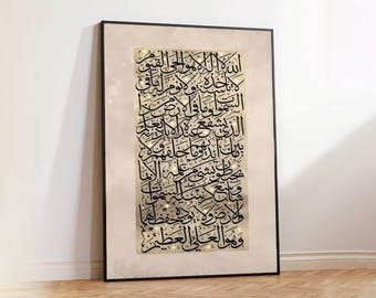 May include: Framed artwork featuring Arabic calligraphy in black ink on a beige background. The calligraphy is ornate and detailed, with a traditional script style. The frame is black, and the artwork is displayed against a white wall and wooden floor.