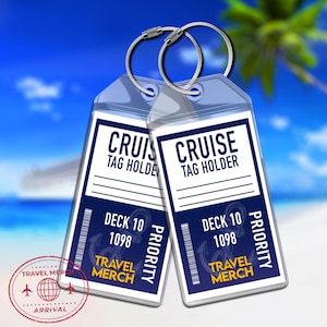 Puede incluir: Dos portaetiquetas de crucero de plástico transparente con anillos plateados. Cada etiqueta tiene un diseño azul y blanco con las palabras "CRUISE TAG HOLDER", "DECK 10 1098" y "TRAVEL MERCH". La palabra "PRIORITY" está impresa verticalmente.