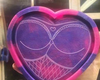 May include: A heart-shaped resin tray with a purple and pink marbled design. The tray features a white lace pattern with a small heart in the center.