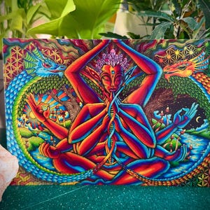 Könnte beinhalten: Ein lebendiger, psychedelischer Kunstdruck mit einer mehrarmigen Figur in meditativer Pose, umgeben von zwei bunten Drachen. Das Kunstwerk ist detailreich, mit einer Mischung aus roten, blauen und grünen Farbtönen und komplizierten geometrischen Mustern.