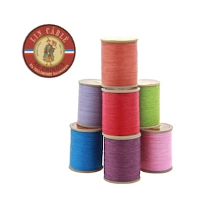 Puede incluir: Una pila de ocho carretes de hilo de varios colores, incluyendo rojo, rosa, morado, azul, verde y naranja. Los carretes están etiquetados "Lin Câblé Au Chinois En Toulemonde Successeurs".