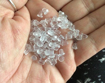 May include: A collection of small, clear earring backs. These earring stoppers are made of a translucent, soft plastic material. These are a small accessory for jewellery.