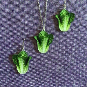 Könnte beinhalten: Ein Set mit grünen Salat-Ohrringen und einer Halskette. Der Schmuck ist aus Silber und hat ein realistisches Salat-Design.