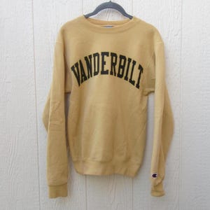 May include: A white ceramic mug with a black handle and the text "But First, Coffee" in a black, handwritten-style font. The mug is on a white surface.