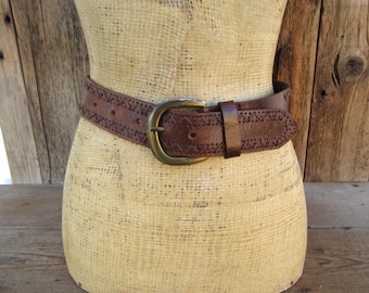 Cinto estilo anos 90 em couro marrom com efeito desgastado e detalhes em costura: fivela em tom de latão, tamanho médio.