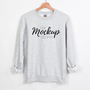 May include: A heather gray sweatshirt with the text "THE Mockup SHOPPE" printed on the front.
