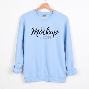 May include: A light blue sweatshirt with the text "THE Mockup SHOPPE" printed on the front.