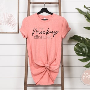 May include: Coral colored t-shirt with a black graphic that says "The Mockup Shoppe" with a camera icon.