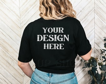 以下が含まれることがあります： 背面に「YOUR DESIGN HERE」という文字が印刷された黒いTシャツです。