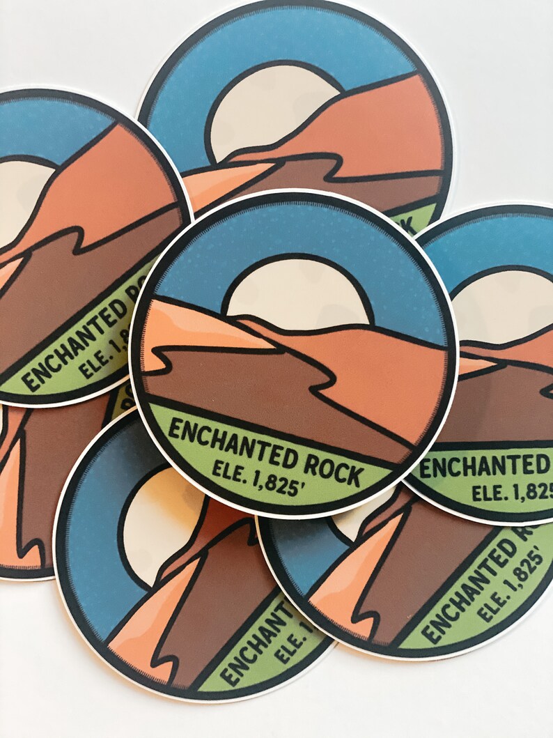 Puede incluir: Una colecci&oacute;n de pegatinas redondas con un dise&ntilde;o de paisaje des&eacute;rtico. Las pegatinas muestran un cielo azul, un sol y monta&ntilde;as marrones y naranjas. El texto "ENCHANTED ROCK ELE. 1,825'" est&aacute; impreso en cada pegatina.