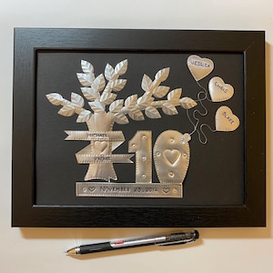 May include: A silver metal family tree with the names Michael, Rachel, Jessica, Chris, and Blake. The tree is surrounded by a black frame and the date November 23, 2014 is inscribed below the tree.