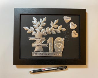 May include: A silver metal family tree with the names Michael, Rachel, Jessica, Chris, and Blake. The tree is surrounded by a black frame and the date November 23, 2014 is inscribed below the tree.