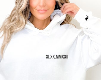 Pode incluir: Camisola de moletom branca com capuz com um design bordado preto que diz "XI.XX.MMXXII".
