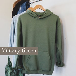 May include: A military green hooded sweatshirt with a kangaroo pocket.