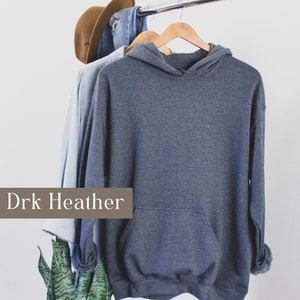 May include: Dark heather grey hooded sweatshirt hanging on a hanger. The sweatshirt has a kangaroo pocket.