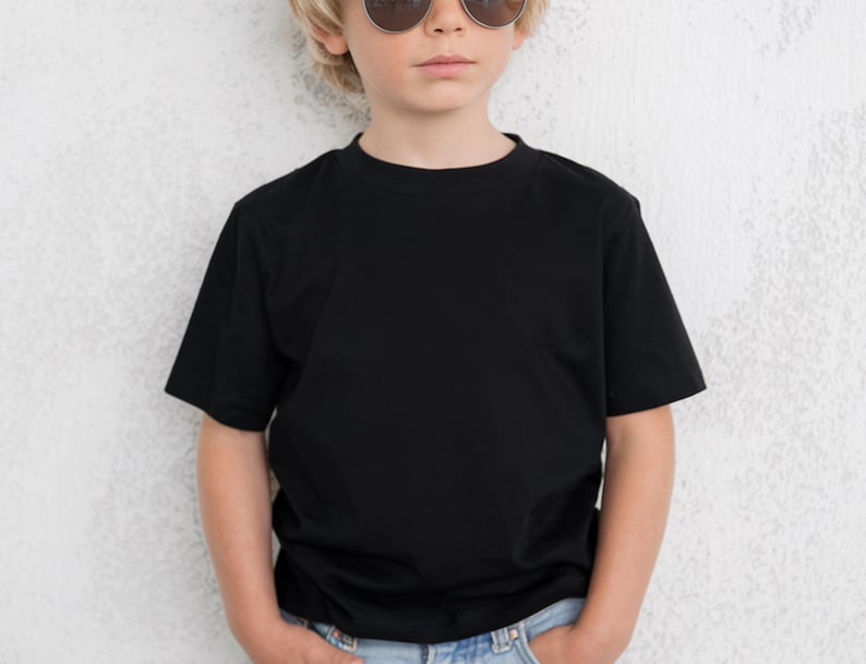 May include: A black crew neck t-shirt. The short-sleeved shirt is worn by a person wearing sunglasses and blue jeans. The shirt is made of a soft, comfortable material.