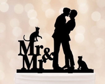 May include: Black silhouette cake topper of two grooms kissing with the text "Mr & Mr" and two cats on either side.