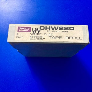 May include: A white box with black text that reads "OHW220 25 FOOT 8ths ONLY WHITE CLAD STEEL TAPE REFILL WITH HOOK" and a purple logo that reads "LUFKIN".