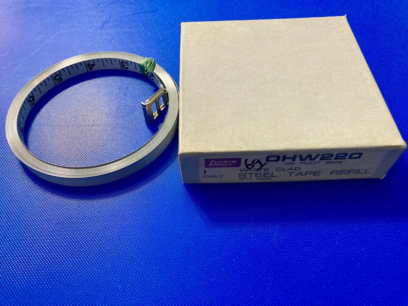May include: A Lufkin 25 foot tape measure refill in a brown box. The box says "1 Only White Clad Steel Tape Refill with Hook" and the model number is "OHW220".