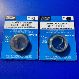 May include: Two packages of white tape refills for measuring tapes. The packages are blue and white and feature the text "White Clad Tape Refill" and "Fits Most Popular Brands". The tape is 10 feet long and 3/4 inch wide.