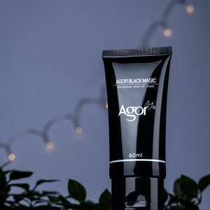 May include: A black tube of face mask with the text "AGOR BLACK MAGIC Blackhead peel-off mask Agor" and "60ml" printed on the front.