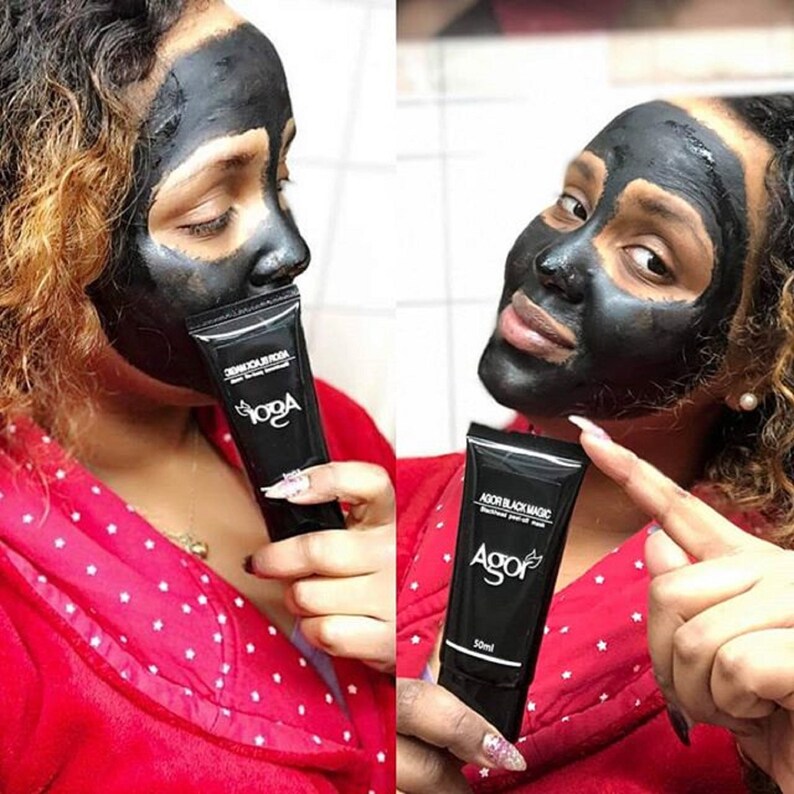 May include: Two people are wearing black face masks. One person is holding a black tube of face mask with the text "ADOR BLACK MAGIC" and "AGOR" on it. The tube is 50 ml.