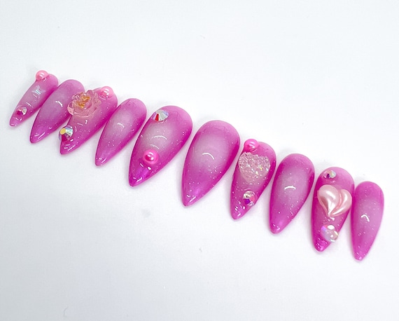 The charms on these pink aura nails give it the perfect final touch 🤍