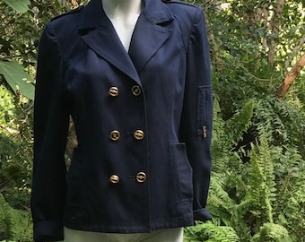 Könnte beinhalten: Ein dunkelblauer zweireihiger Blazer mit goldenen Knöpfen und einer Reißverschlusstasche am Ärmel.