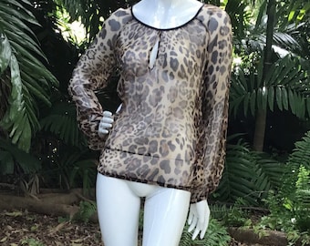 May include: A sheer, brown and black leopard print blouse with a keyhole neckline and long sleeves.