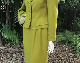 May include: A lime green skirt suit with a fitted jacket and a skirt that falls to the knee. The jacket has a notched collar, a button closure, and two flap pockets. The skirt has a waistband and a straight silhouette.